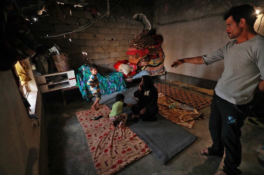 Iraqi father-of-five Issa al-Zamzoum stands inside his damaged house in the war-ravaged village of Habash 