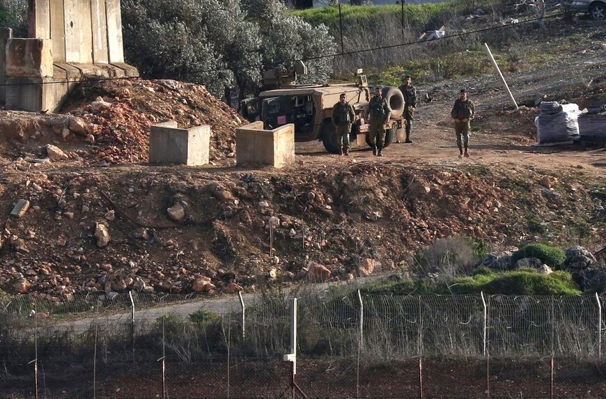 Israeli troops behind the fence with Lebanon, seen from southern Lebanon's Khiam plain near the Israeli northern border town of Metulla, on February 18, 2022