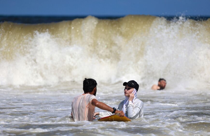 Sabah Abu Ghanem trains with her brother as a wave comes crashing down