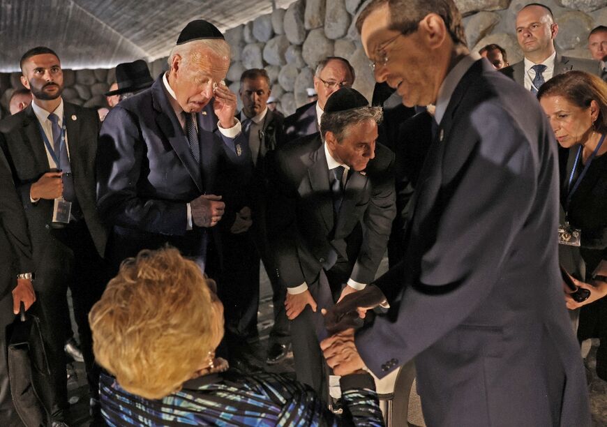 US President Joe Biden, standing to the left of US Secretary of State Antony Blinken, reacts as Israel's President Isaac Herzog speaks with Holocaust survivor Rena Quint, at the Yad Vashem Holocaust Memorial museum