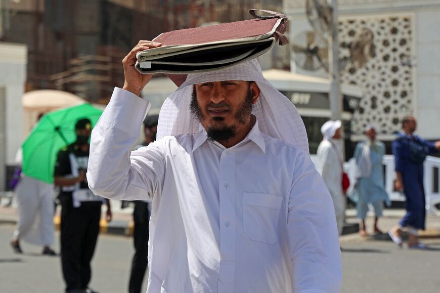 Islam forbids men from wearing hats once the hajj rites start, leading many to shield themselves from the blazing sun in various way