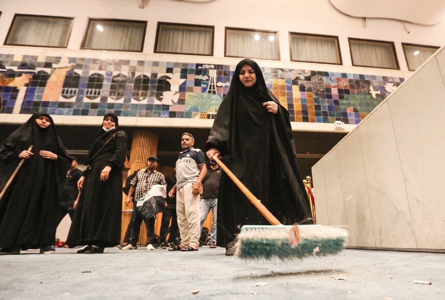 A woman sweeps the floor during the occupation of Iraq's parliament