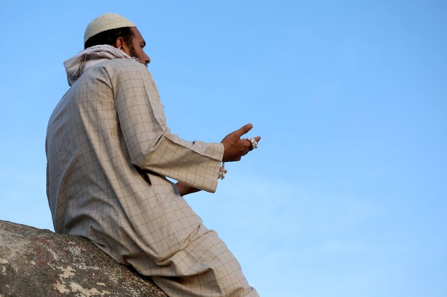 A Muslim pilgrim prays at Jabal al-Noor 'mountain of light' in Mecca. Temperatures in the holy city topped 40 degrees Celsius (104 degrees Fahrenheit) on Tuesday
