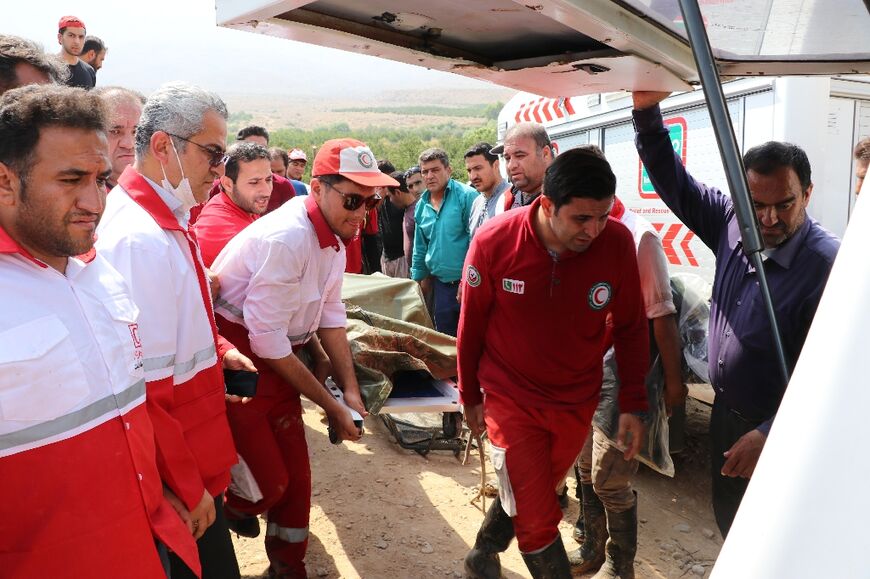 Rescue workers evacuate a body after flooding in the southern province of Fars