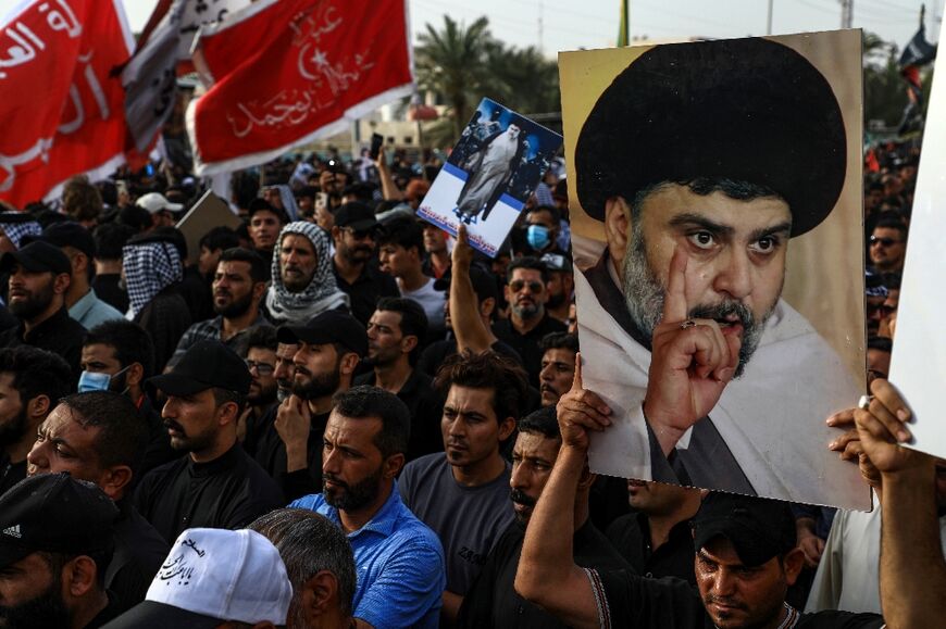 Supporters of Shiite cleric Moqtada Sadr carry portraits of him as they gather in the city of Nasiriyah in Iraq's southern Dhi Qar province on August 12, 2022