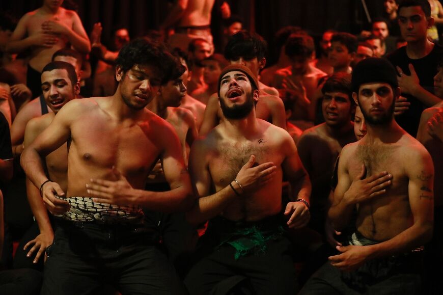 Iraqi Shiite Muslims take part in a ritual of mourning in Sadr City in eastern Baghdad late on August 7, 2022, to mark Ashura