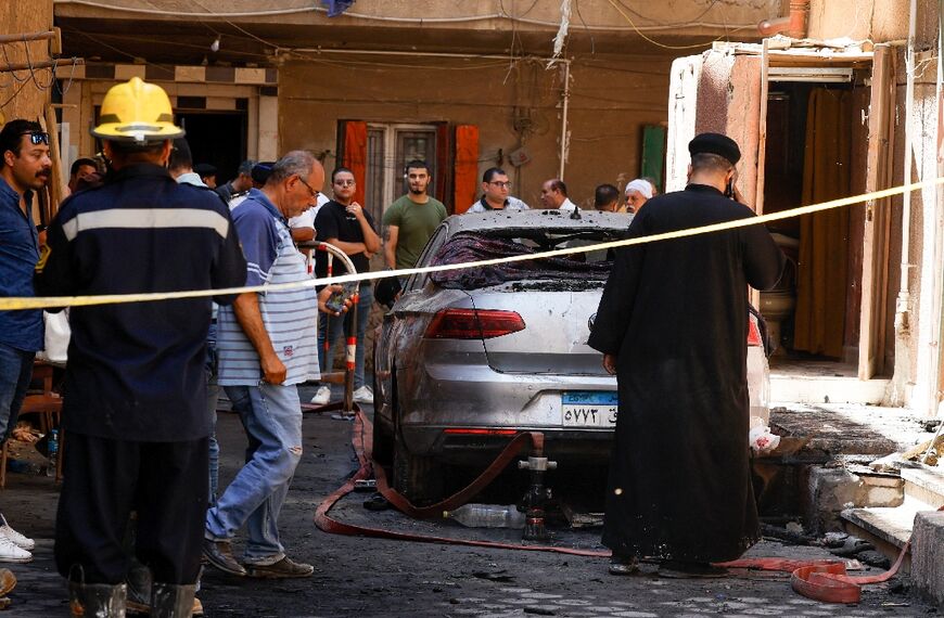 A Coptic priest outside Abu Sifin church -- a witness said some people threw themselves out windows to escape the blaze, and one landed on a car