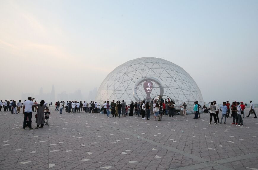 People gather near the dome housing the Qatar World Cup countdown clock 