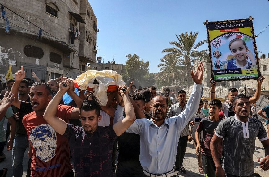 Mourners in Khan Younis, the southern Gaza Strip, carry the body of Palestinian child Lian al-Shaer after she succumbed to injuries sustained in Israeli air strikes