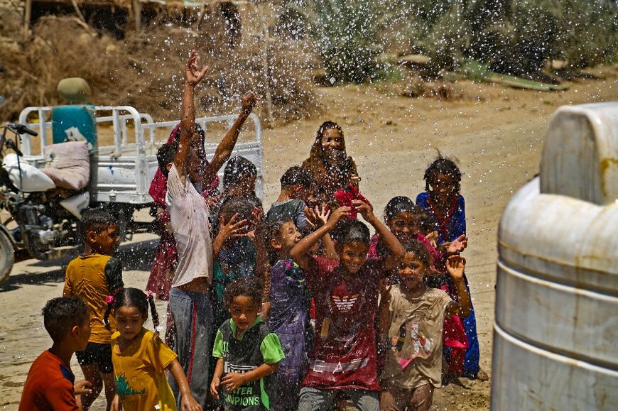 Children are sprayed with water when it is delivered to their village: Iraq is known in Arabic as the Land of the Two Rivers, but it has seen water levels on the once mighty Tigris and Euphrates plummet