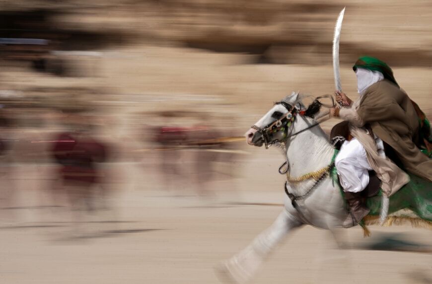 Shiite Muslims re-enact the Battle of Karbala as they mark the peak of Ashura, a 10-day period commemorating the seventh century killing of Prophet Mohammed's grandson Imam Hussein, in Iraq's holy city of Najaf on August 9, 2022