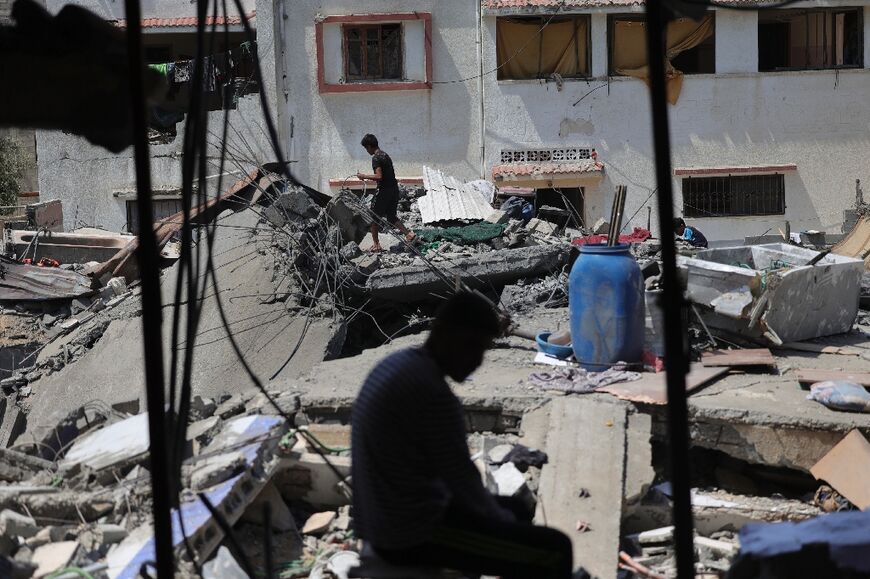 Shamalagh family members sift through the rubble of their flattened home looking for cherished possessions among the concrete slabs