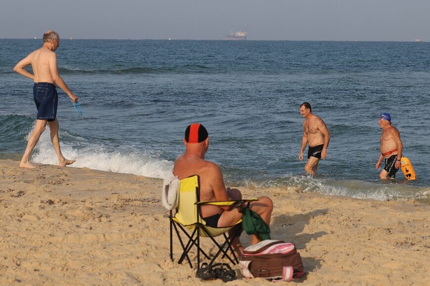 Israelis from the southern coastal city of Ashkelon, near the border with the Gaza Strip, return to the beach after an overnight truce, on August 8, 2022