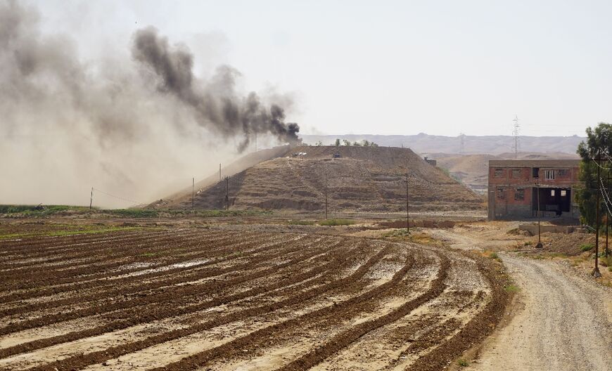 Smoke billows over the village of Altrun Kupri, in the Sherawa region, south of Arbil in Iraq's Kurdistan, where a base of the Kurdistan Freedom Party is located, on September 28, 2022