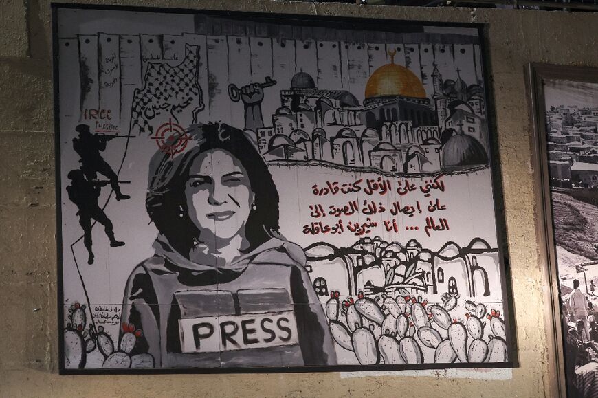 A mural depicting slain Palestinian-American journalist Shireen Abu Akleh is illuminated with headlights on a street in the Arab town of Umm Al-Fahm in northern Israel, on September 5, 2022