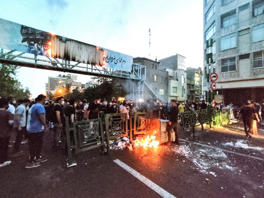 A picture obtained by AFP outside Iran on September 21 shows Iranian demonstrators burning a rubbish bin in the capital Tehran during a protest for Mahsa Amini following her death