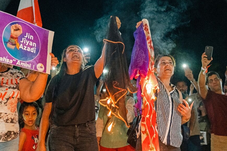 Women burn headscarves during a rally in Cyprus' southern coastal city of Limassol 