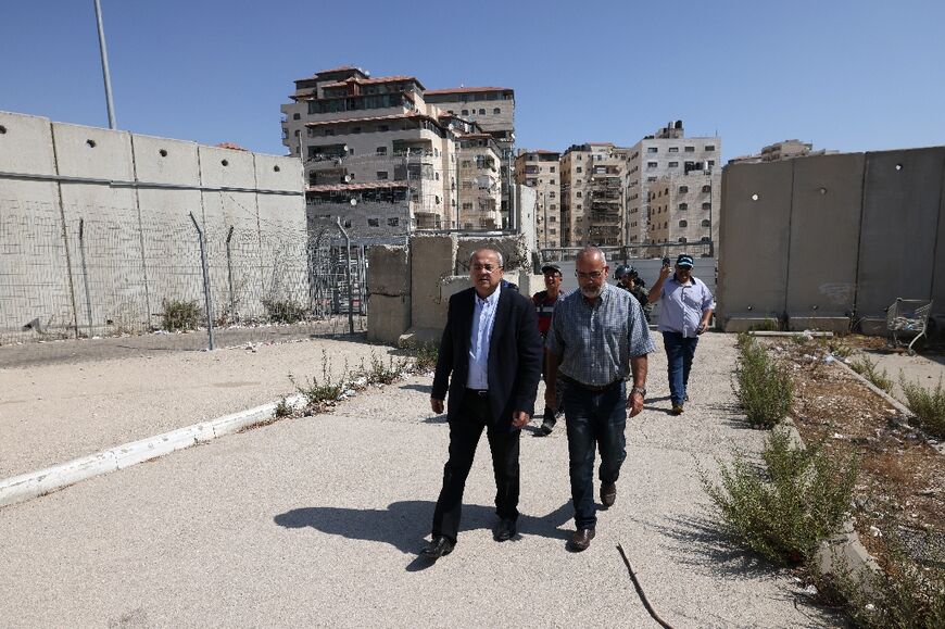 Arab-Israeli lawmaker Ahmad Tibi (L) tours Jerusalem's Shuafat refugee camp with fellow MP Oussama al-Saadi to check on conditions for residents in the face of the Israeli manhunt