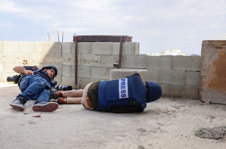 Journalists take cover during an operation by Israeli security forces in Jenin city in the occupied West Bank, after two reporters were wounded Wednesday