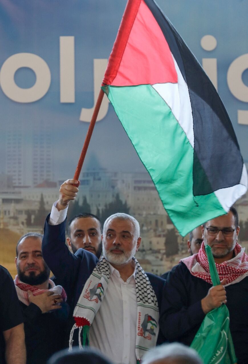 The Hamas movement's leader Ismail Haniyeh waves the Palestinian flag at a public rally during a visit to the southern Lebanese city of Saida, on June 26, 2022