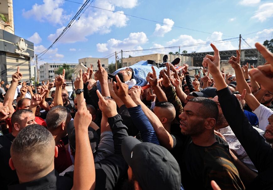 Palestinian mourners carry the body of Mateen Debaya, killed during an Israeli raid, ahead of the funeral in the flashpoint city of Jenin