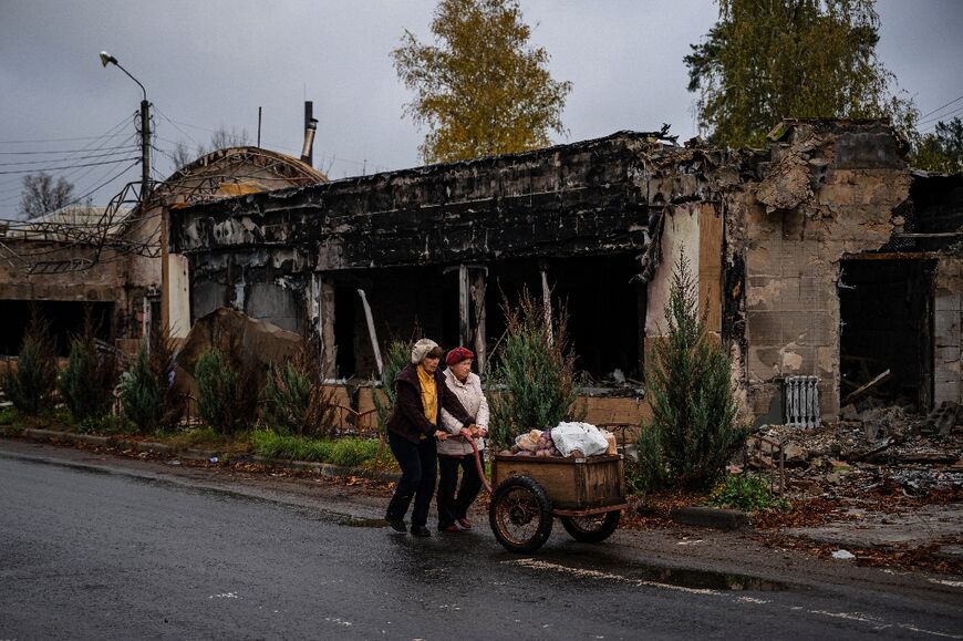 Residents push a cart of potatoes received as humanitarian aid down a street in Svyatohirs'k, Donetsk 