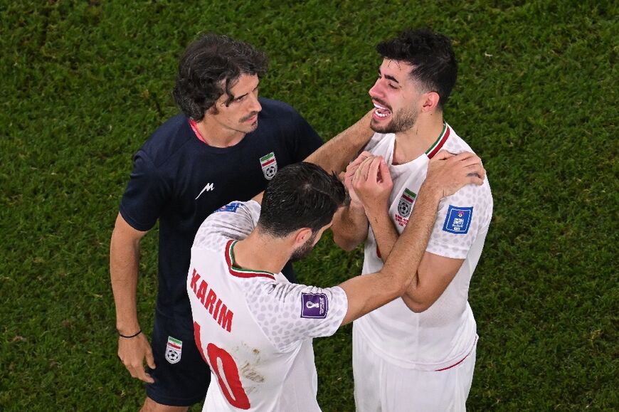 Iran's forward #10 Karim Ansarifard and Iran's midfielder #06 Saeid Ezatolahi cry after the narrow loss to the US