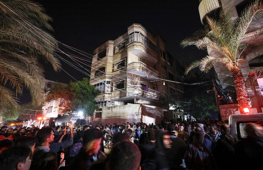 A large crowd of onlookers gathered on the street outside the multi-storey home from which plumes of smoke billowed 