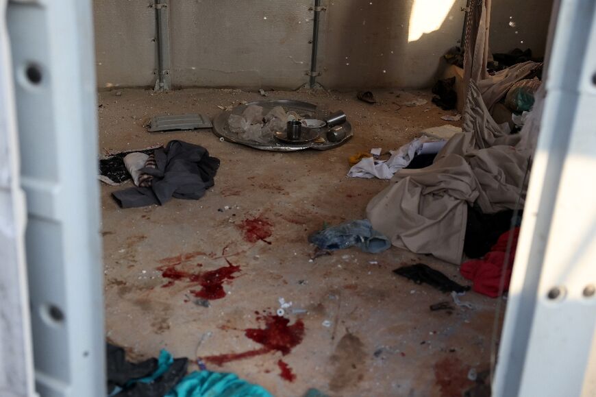 Blood stains and personal belongings are strewn on the floor of a shack for displaced persons after the shelling