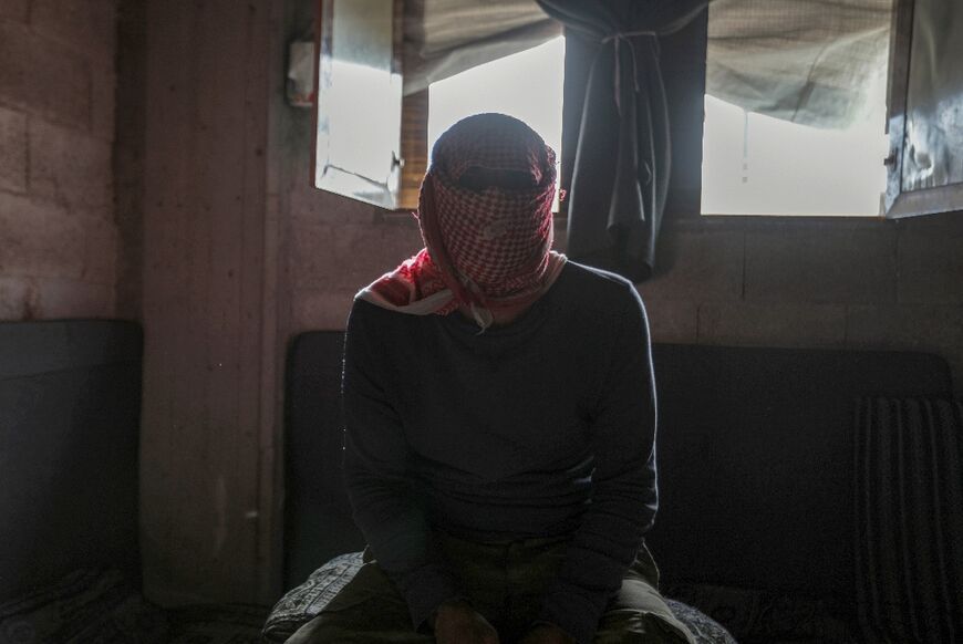 A masked captagon dealer in the Syrian city of Aleppo talks to AFP