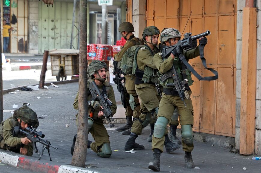 Israeli army soldiers take aim during clashes with Palestinian protesters in Hebron in the occupied West Bank on May 29, 2022: according to UN data, 2022 has been deadliest year since the 2002-2005 Palestinian uprising