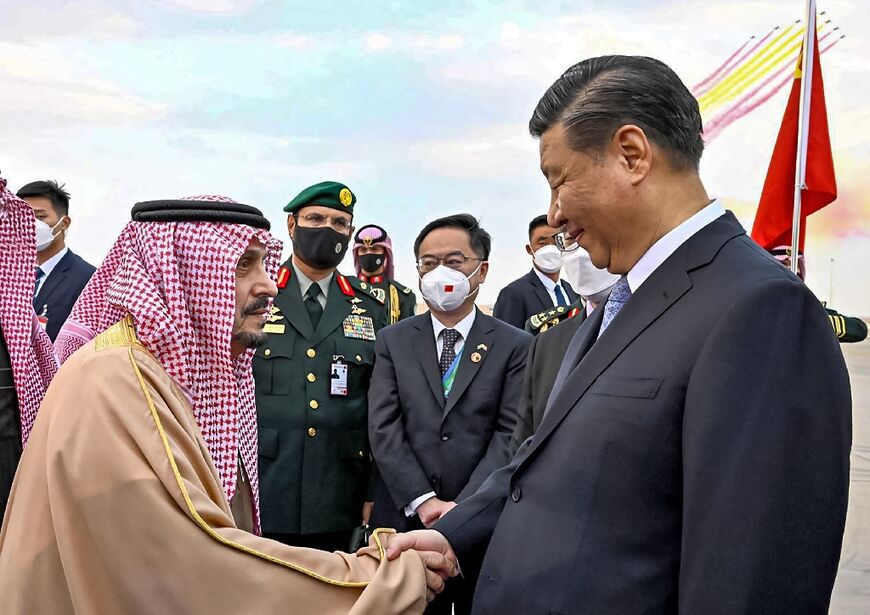 China's President Xi Jinping (R) greeted by the Governor of Riyadh province Prince Faisal bin Bandar al-Saud (L) at King Khalid International Airport