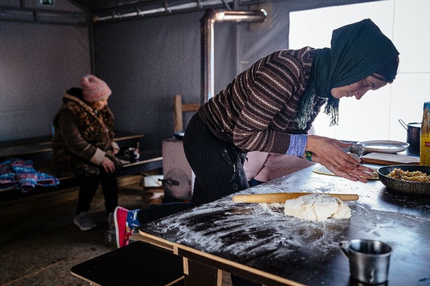 A Borodianka local cooks inside tents to keep warm after her home was destroyed