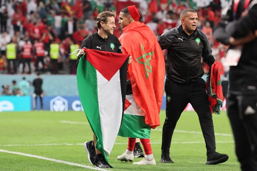 A member of Morocco's team holds a Palestinian flag after the team beat Spain