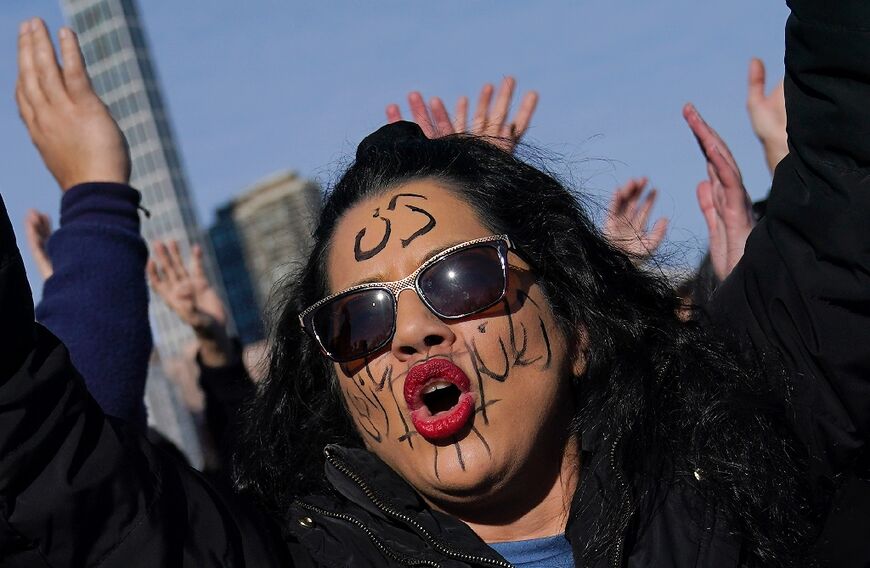 People pose for a photo as artist JR, in partnership with For Freedoms, Vital Voices, and the Woman, Life, Freedom global coalition of Iranian women leaders, holds one of his participatory performances in New York on December 4