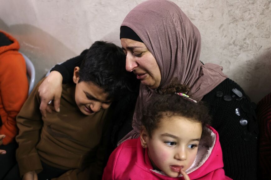 Palestinian relatives mourn during the funeral of Samir Aslan, 41, at Qalandia refugee camp in the occupied West Bank, on January 12, 2023