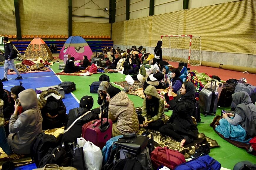 Iranians take shelter inside a building after the quake struck the area near the border with Turkey late Saturday