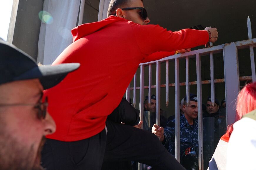 A relative of a victim of the 2020 Beirut port explosion tries to climb the gate of the palace of justice in the Lebanese capital during a rally on Thursday