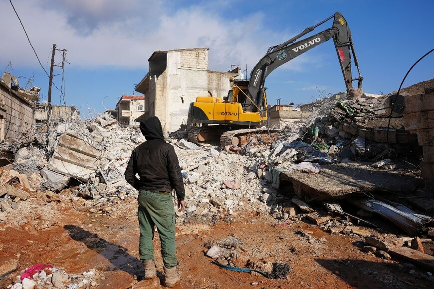 A Syrian boy watches as an excavator digs the rubble of the house in which the newborn baby was found