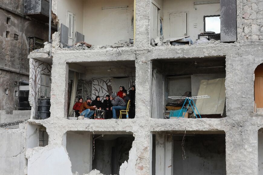 Ali al-Bash and his mother Amina Raslan drink coffee at home, in a building damaged by the 7.8-magnitude quake, in Aleppo city's al-Masharqa neighbourhood