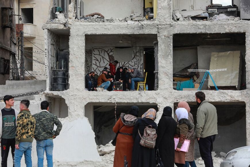 Ali al-Bash and his mother Amina Raslan drink coffee at home, in a building heavily damaged by the 7.8-magnitude quake, in Aleppo city's al-Masharqa neighbourhood