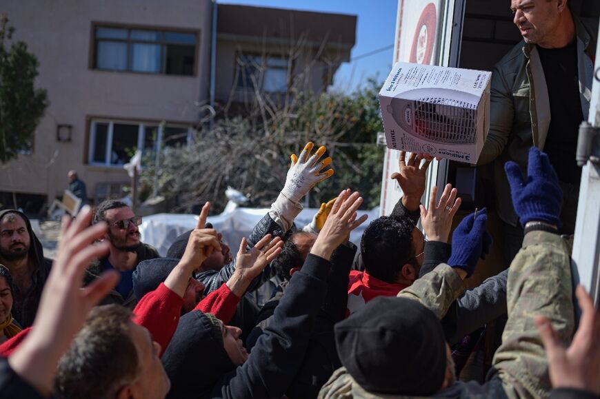 Desperate residents grab food, clothes and household items handed out by a private donor
