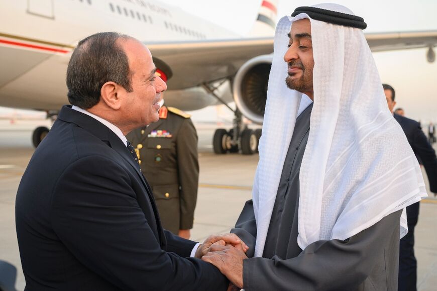 A handout picture released by the United Arab Emirates' presidential court shows Emirati President Sheikh Mohamed bin Zayed Al-Nahyan (R) welcoming Egypt's President Abdel Fattah al-Sisi in Abu Dhabi on February 12, 2023 