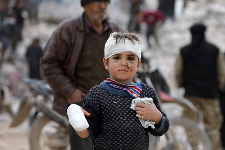 Six-year-old Musa Hmeidi shows off his bandages after being pulled alive from the rubble of the family home in the rebel-held Syrian town of Jindayris