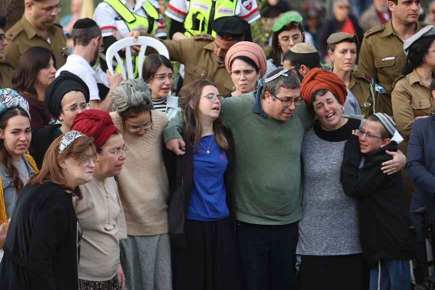 The parents of Israeli settlers, brothers Yagel Yaniv, 20, and Hallel Yaniv, 22, mourn during their funeral at the military cemetery in Jerusalem