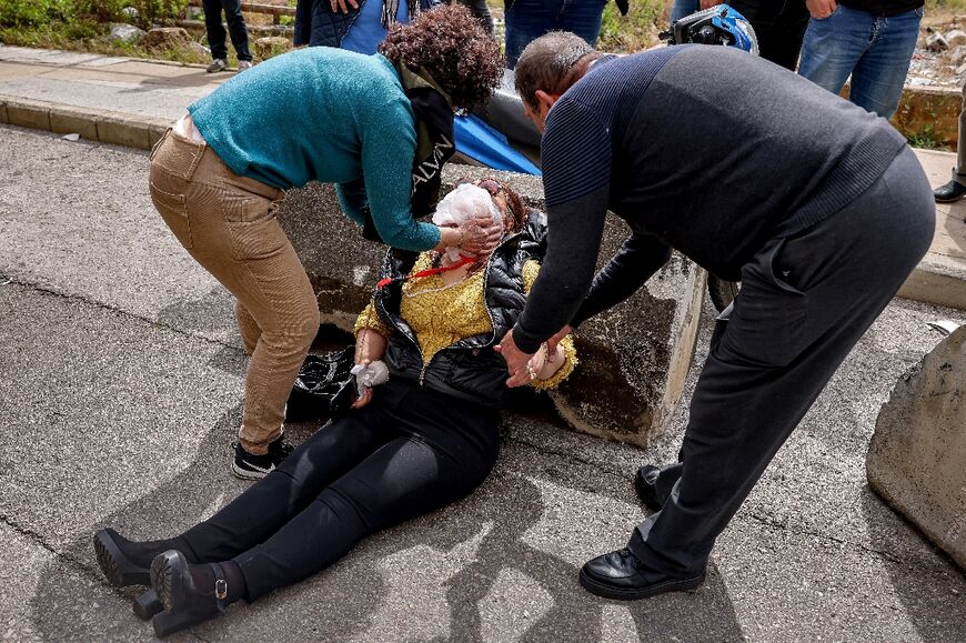 People tend to a woman affected by tear gas fumes 