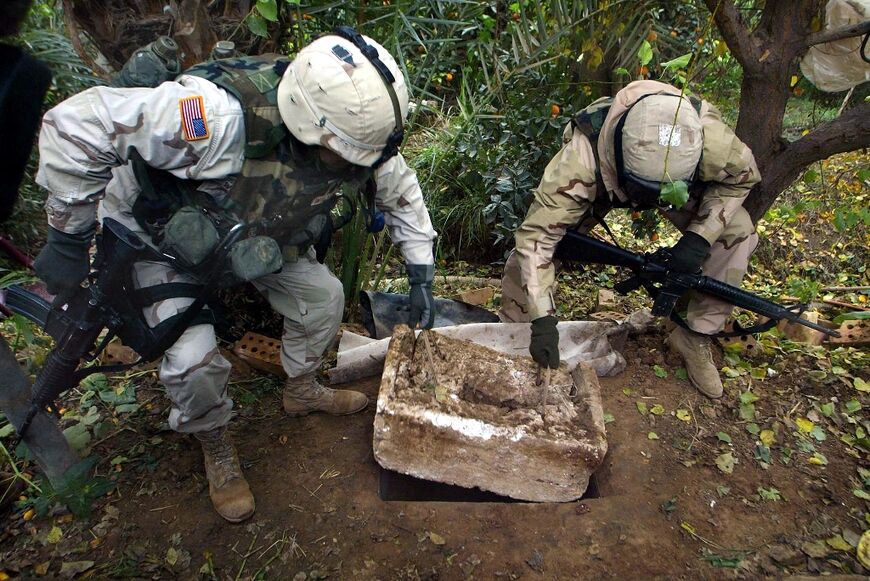 US soldiers show the hole where toppled Iraqi dictator Saddam Hussein was captured in Ad Dawr, near his hometown of Tikrit, in this file photo from December 15, 2003 