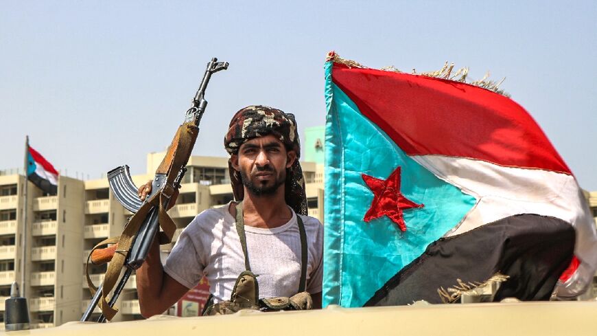 A Yemeni fighter brandishes the flag of the formerly independent south, the emblem of a powerful separatist movement whose grievances persist despite the detente under way between regional heavywights Iran and Saudi Arabia