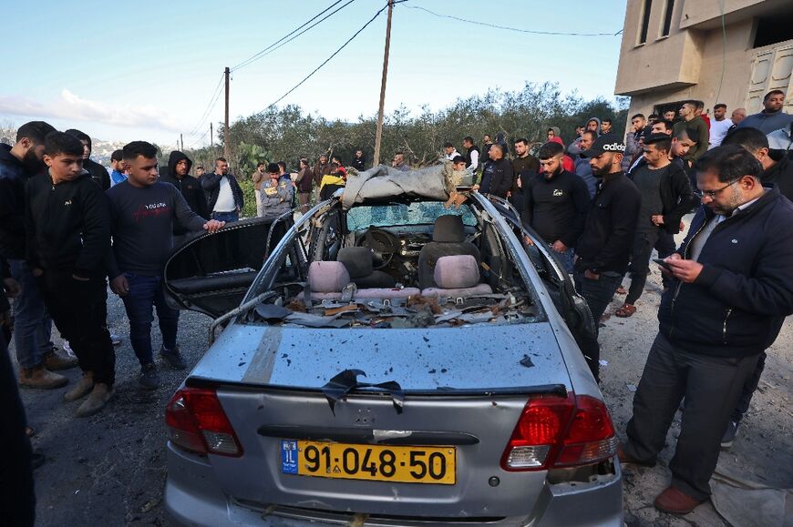 Palestinians inspect the bullet-riddled car in which three suspected militants were shot dead by Israeli undercover agents just hours before Pentagon chief Lloyd Austin was due in Israel for talks