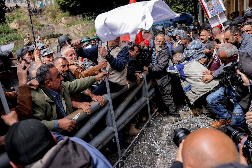 A group of protesters breaks through the security barriers thrown up around the government office compound in central Beirut